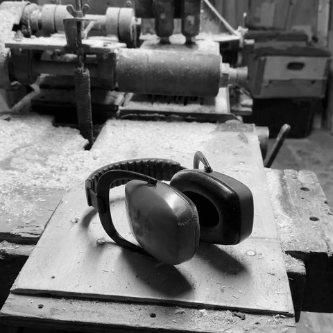 protective ear defenders placed on workbench in woodturning workshop
